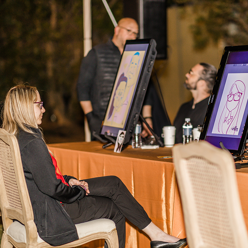 Woman seated at an event admiring a digital artwork