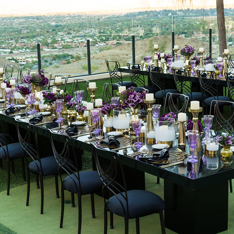 two long rectangular tables decorated in black, blue, and purple for an outdoor dining experience in Palm Springs
