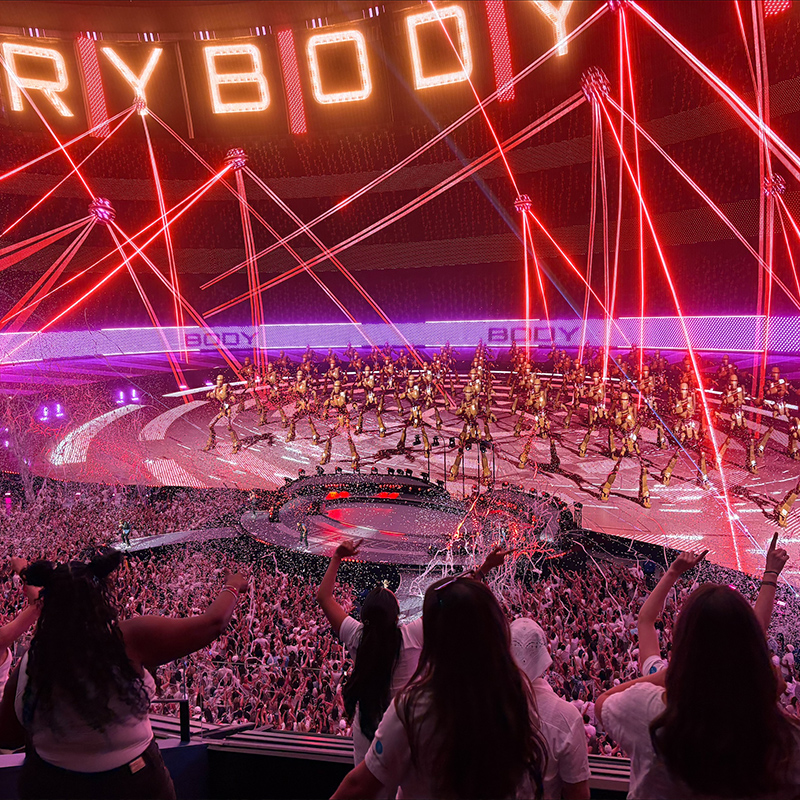 people enjoying a performance on a neon lighted stadium