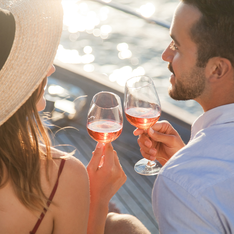 a man and a woman drinking wine on a cruise