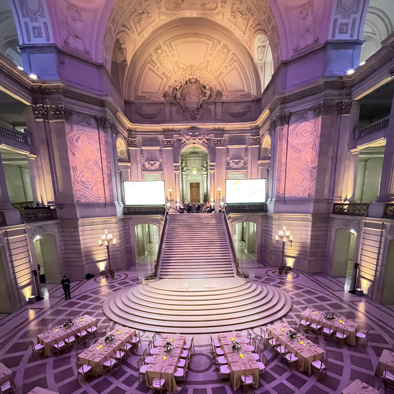 An interior of a historical building with table and chairs set up for guests