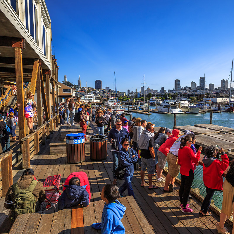 people gathered for a tour in a dock, enjoying the view of the water and surrounding scenery