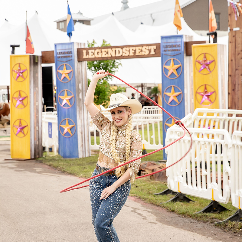 a woman on a cowboy costume attending a western themed festival