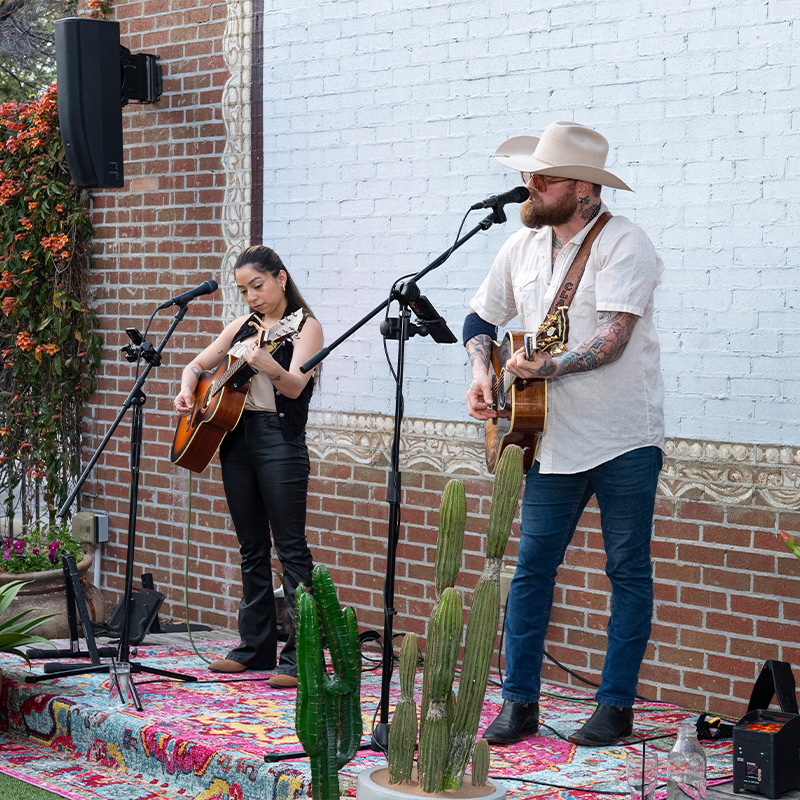 two performers singing on stage with western style decor